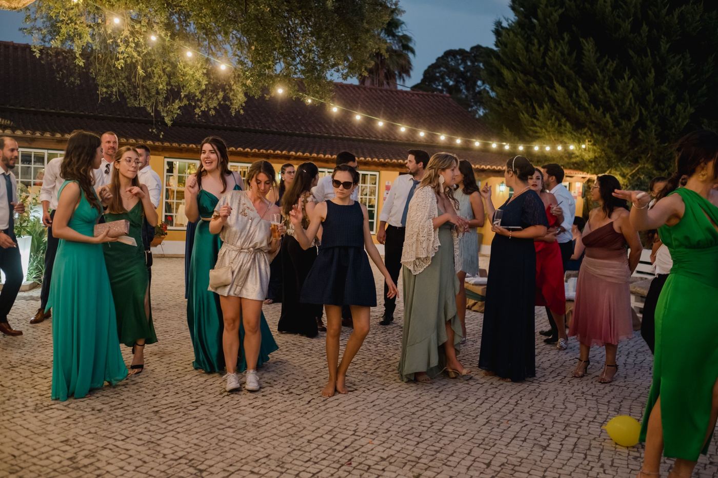 Convidados a dançar no pátio ao anoitecer