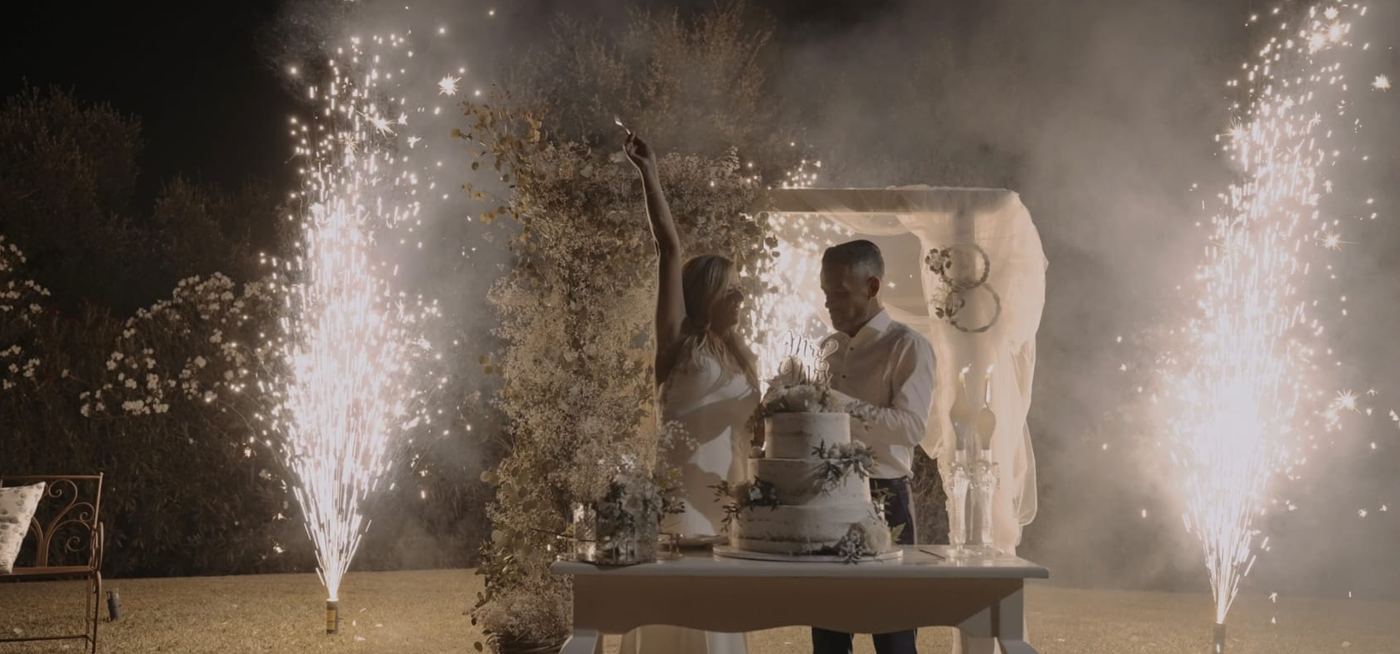 Noivos a celebrar o bolo com fontes de luz