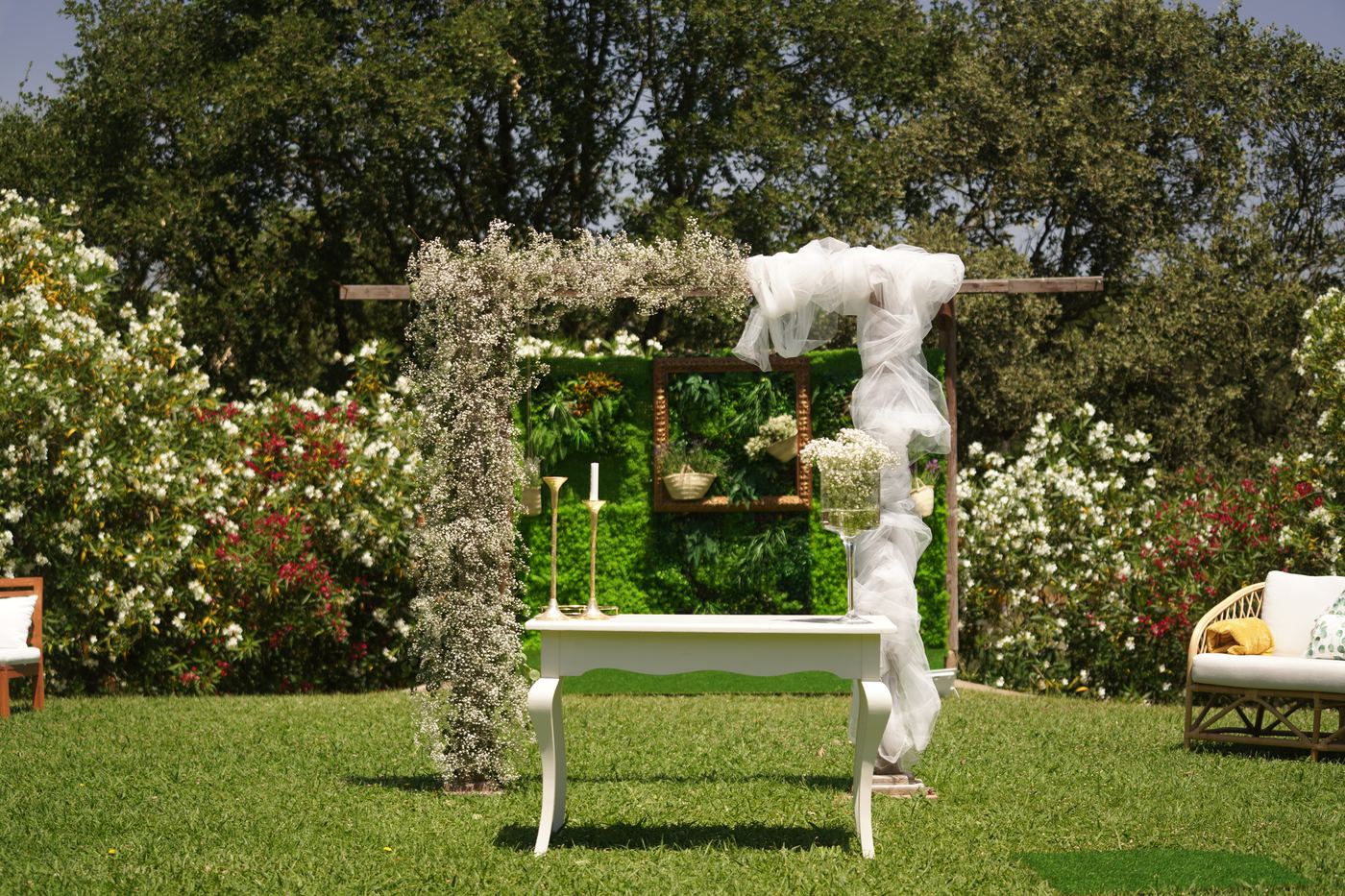 Altar no relvado com arco de flores e tule
