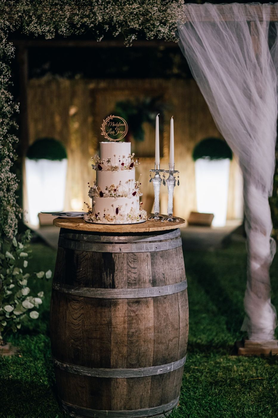 Bolo de casamento junto ao arco de tule